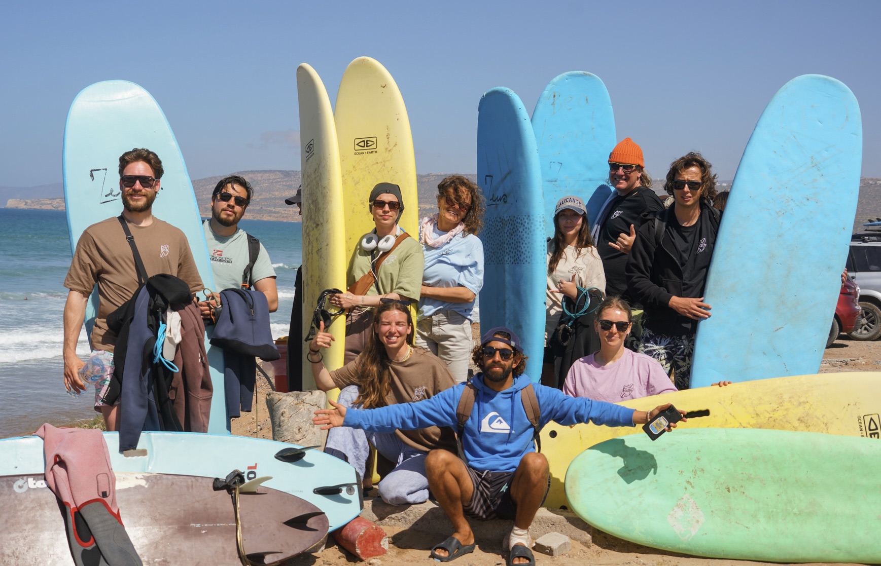 Grupa surferów z deskami po zajęciach na plaży