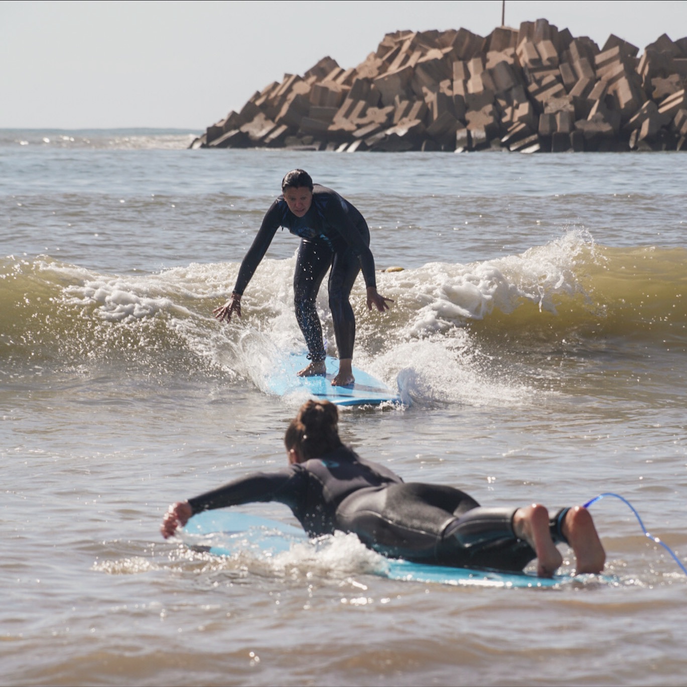 Uczestnik uczy się surfingu w płytkiej wodzie